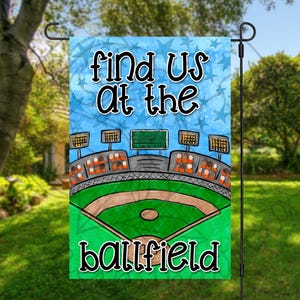 May include: A blue and white garden flag with a baseball field illustration and the text "Find us at the ballfield".