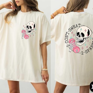 a woman wearing a white shirt with a skull on it
