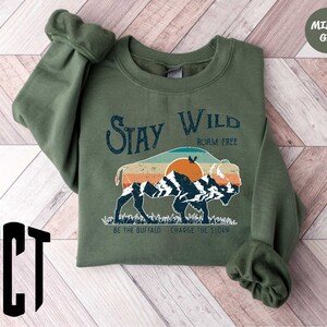 a green sweatshirt with a picture of a bear on it