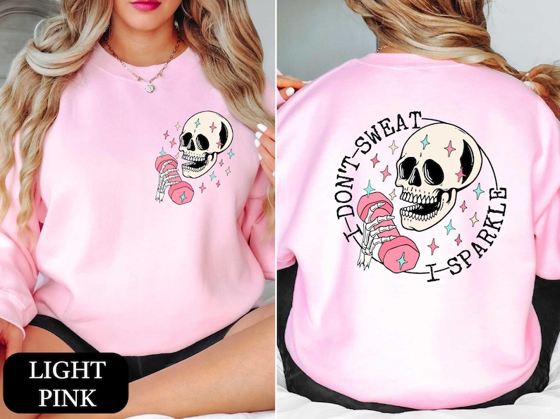 a woman wearing a pink sweatshirt with a skull on it