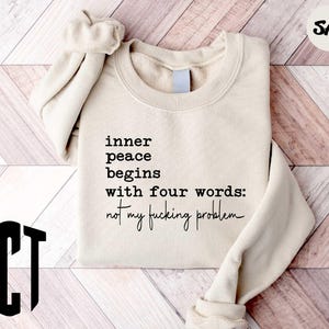 a sweater with a quote on it sitting on a wooden floor