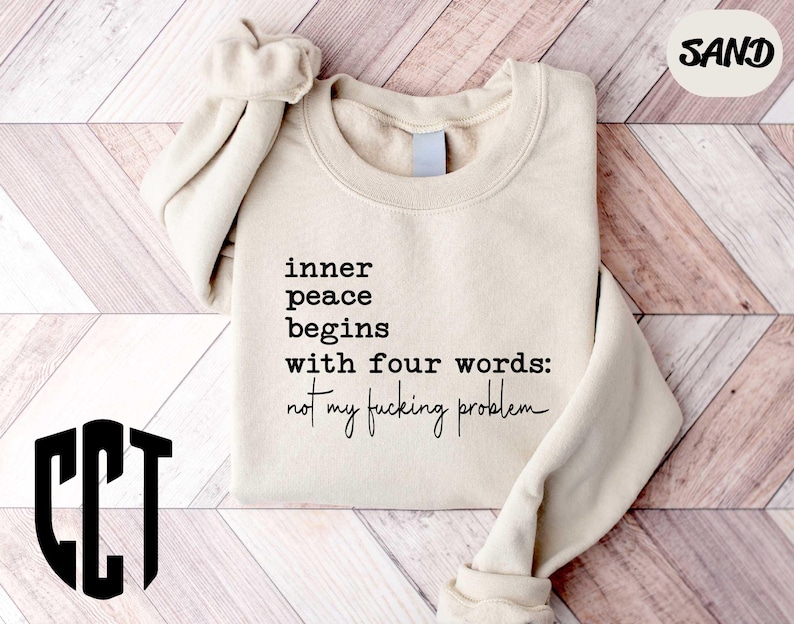 a sweater with a quote on it sitting on a wooden floor