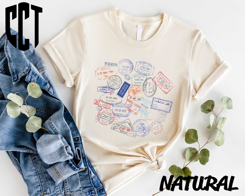 a t - shirt with stamps on it next to a pair of jeans