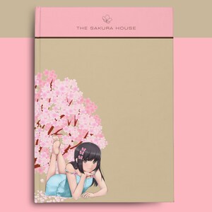 May include: A pink and brown notebook with the text "THE SAKURA HOUSE" on the front cover. The notebook features an illustration of a young woman with long black hair lying in a field of pink cherry blossoms.