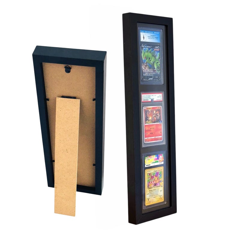 Op de afbeelding: Zwart houten displayframe met drie zichtbare ruilkaarten. Het frame heeft een zwarte rand en een doorzichtige voorkant. De achterkant van het frame heeft een standaard voor presentatie op tafel. De kaarten zitten in beschermhoezen.