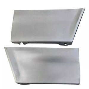 May include: Two silver-colored car body panels. Each panel is rectangular with a beveled edge and a curved bottom. One panel has a small hole and a curved indentation. The panels appear to be new and unused.