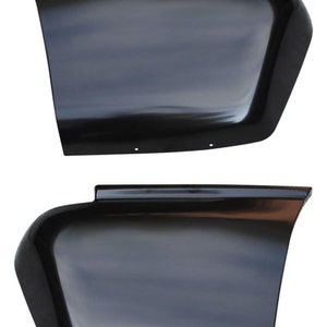 May include: Two black plastic fender flares for a vehicle. The flares are curved and have a smooth, glossy finish.