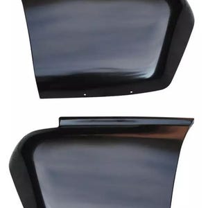 May include: Two black plastic car fender flares. The flares are curved and have a smooth, glossy finish.