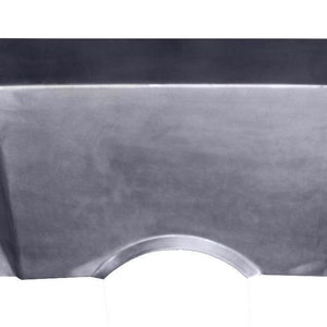 May include: A metal automotive floor pan replacement part with a cutout for a transmission tunnel.
