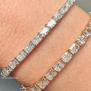 Puede incluir: Dos pulseras de tenis con diamantes de corte cuadrado engastados en metal. Una pulsera es de metal plateado y la otra de metal dorado. Ambas piezas muestran una hilera continua de piedras brillantes. El texto dice ParryGoldJewels.