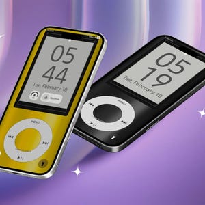 May include: Two digital music players, one gold and one black, with a silver trim. The screens display the time and date. The gold player shows 05:44, and the black player shows 05:19. Both have a circular control pad.