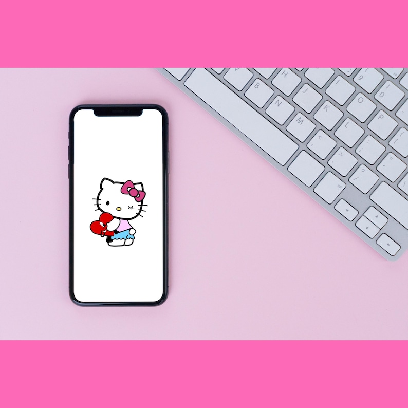 Puede incluir: Un tel&eacute;fono inteligente blanco con una pantalla negra que muestra una imagen de dibujos animados de Hello Kitty sosteniendo un coraz&oacute;n rojo. El fondo es rosa.
