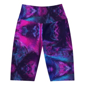 Puede incluir: Pantalones cortos de yoga de cintura alta con un patrón abstracto vibrante. El diseño presenta una mezcla de tonos rosa, azul y morado, creando un efecto visual dinámico. Los pantalones cortos están diseñados para la comodidad y la flexibilidad.