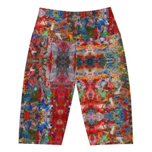 May include: High-waisted yoga shorts with a vibrant, abstract paint-splatter design. The shorts feature a kaleidoscope of colors including red, blue, green, and yellow. The pattern is symmetrical, creating a unique visual effect. These shorts are designed for comfort and flexibility.
