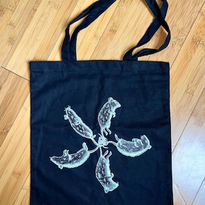 May include: Black canvas tote bag with a white design of five mice in a circle.