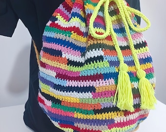 Könnte beinhalten: Ein bunter gehäkelter Rucksack mit Kordelzug und neon gelben Kordeln und Quasten. Die Tasche ist aus verschiedenen farbigen Garnen gefertigt.