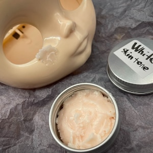Modeling paste, craft supplies, customizing tools, and a UV lamp for doll face making. Modeling paste is often used to sculpt facial features, while customizing tools can be used to add details like lips or eyeshadow.