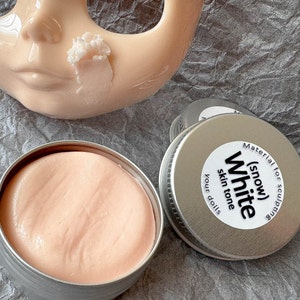 Modeling paste, craft supplies, customizing tools, and a UV lamp for doll face making. Modeling paste is often used to sculpt facial features, while customizing tools can be used to add details like lips or eyeshadow.