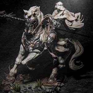 Può includere: Statuetta dettagliata di un cavaliere a cavallo di un cavallo bianco. Il cavaliere è vestito con un'armatura scura e un mantello svolazzante, che tiene una lancia. Il cavallo ha un'armatura ornata color argento ed è posato su una base rocciosa con erba.