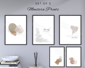 May include: Set of 5 framed Monstera prints. Each print features minimalist line art of Monstera leaves and abstract shapes in neutral tones of brown, beige, and white. One print reads "Be-leaf in yourself" and another reads "Be kind".
