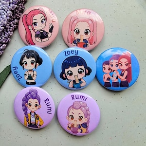 May include: Seven round pin badges with anime-style illustrations of girls. Each badge features a different girl with unique hairstyles and outfits. The badges are in shades of pink, blue, and purple.