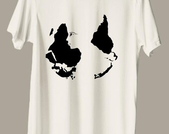 Puede incluir: Camiseta blanca con una silueta negra de una cara en la parte delantera.