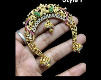 May include: Gold nose ring with green and pink stones, intricate design, and three dangling bells. Style 1.