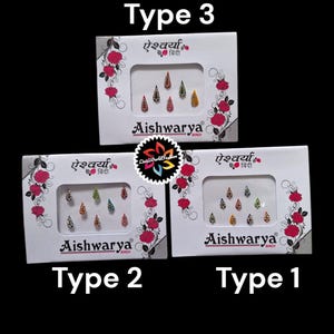 Puede incluir: Tres paquetes de bindi de la marca Aishwarya, un tipo de decoración para la frente. Los paquetes son blancos con flores rosas y el texto "Aishwarya" y "ऐश्वर्या बिंदी" en negro. Los paquetes están etiquetados como "Tipo 1", "Tipo 2" y "Tipo 3".