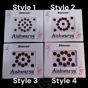 May include: Four white cards with brown round stickers arranged in different patterns. The cards are labeled "Style 1", "Style 2", "Style 3", and "Style 4". Each card has the text "Simran®" and "Aishwarya® Bindi" printed on it.