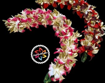 May include: Three flower leis with white, pink, and red flowers. The leis are decorated with gold glitter.