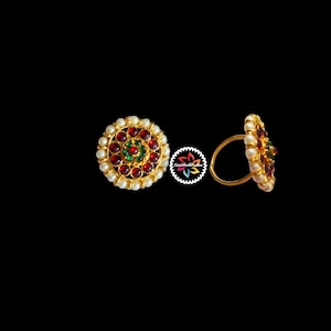 May include: A pair of gold nose rings with red and green gemstones and white pearl accents.