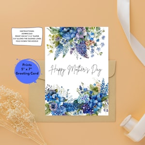 May include: Printable greeting card featuring a watercolor illustration of blue flowers with the text "Happy Mother's Day". The card is 5 inches by 7 inches.