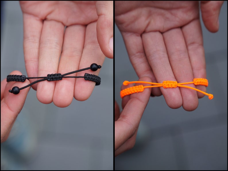 Pode incluir: Duas pulseiras ajust&aacute;veis, uma preta com contas pretas e outra laranja brilhante.