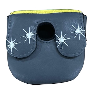 K&ouml;nnte beinhalten: Ein grauer Putter-Schl&auml;gerhaube mit einem gelben Streifen am oberen Rand und wei&szlig;en, gestickten Sternmotiven. Die H&uuml;lle verf&uuml;gt &uuml;ber eine mittige kreisf&ouml;rmige Aussparung und eine glatte, lederartige Textur mit gen&auml;hten Kanten.