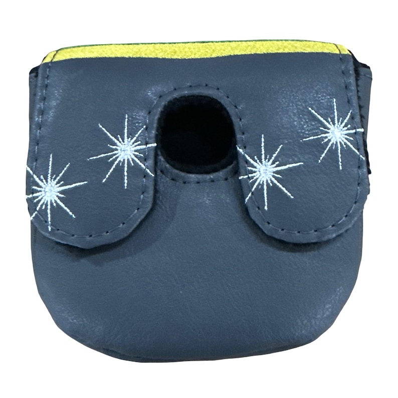 K&ouml;nnte beinhalten: Ein grauer Putter-Schl&auml;gerhaube mit einem gelben Streifen am oberen Rand und wei&szlig;en, gestickten Sternmotiven. Die H&uuml;lle verf&uuml;gt &uuml;ber eine mittige kreisf&ouml;rmige Aussparung und eine glatte, lederartige Textur mit gen&auml;hten Kanten.