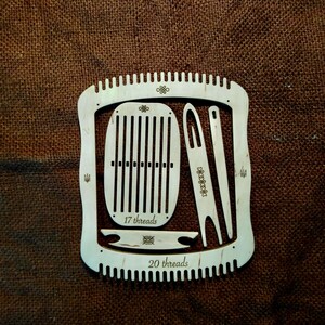 May include: Wooden loom with two weaving frames, one for 17 threads and one for 20 threads. The loom also includes two weaving needles and a shuttle.