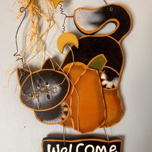 Cartello di benvenuto rustico in legno vintage per Halloween con zucca e gatto nero