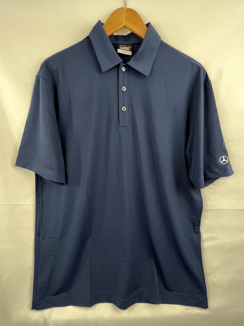 May include: A navy blue short-sleeved polo shirt with a button-up collar and a small logo on the right sleeve.