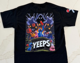 May include: A black short-sleeve t-shirt featuring a large graphic print on the back. The design displays colorful cartoon characters, the text YEEPS, and a dark hooded figure with lightning. A small icon of a red and white tool is on the sleeve.
