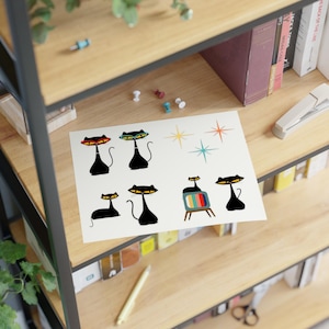 May include: A sheet of black cat stickers with a retro design. The cats have large eyes and are in various poses, including sitting, standing, and watching television. The stickers are perfect for adding a touch of vintage charm to any project.