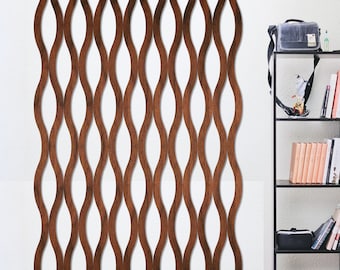 May include: A brown wooden wall panel with a wavy design. The panel is made of thin strips of wood that are woven together to create a unique pattern. The panel is mounted on a white wall and is next to a black bookshelf.