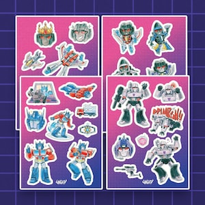 Peut inclure: Quatre planches d'autocollants représentant divers personnages Transformers dans un style artistique chibi. Les motifs incluent Optimus Prime, Megatron, Starscream et d'autres robots sous forme de véhicules et humanoïdes sur un fond dégradé rose et violet.
