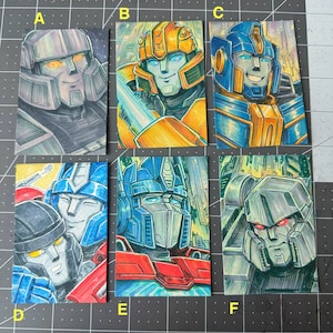 May include: Six colorful, hand-drawn illustrations of Transformers characters. Each features a different character in a portrait style, with detailed shading and vibrant colors. The artwork is on small rectangular cards.
