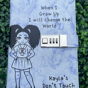 May include: A light blue diary with a combination lock, a black and white illustration of a girl with pink earrings, and the text "Dear Diary, When I Grow Up I will change the World Kayla's Don't Touch".