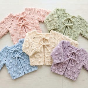 Modello per cardigan da neonato con pompon all'uncinetto, maglione 0-6 mesi in PDF, punto testurizzato per principianti