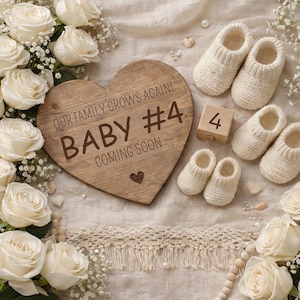 May include: A wooden heart-shaped sign with the text "OUR FAMILY GROWS AGAIN! BABY #4 COMING SOON" is surrounded by white roses and baby booties. A wooden block displays the number 4. The announcement is for a new baby.