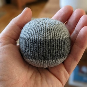 May include: A set of three ceramic mugs with a speckled, matte finish. The mugs are in shades of cream, light gray, and dark gray. Each mug has a simple, minimalist design, perfect for coffee or tea.