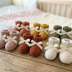 May include: A white ceramic mug with a black handle and the text "But First, Coffee" in a bold, black font. The mug is set against a neutral background, highlighting its simple design.