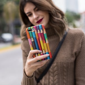 Könnte beinhalten: Eine farbenfrohe Handyhülle mit einem Design aus gestapelten Buntstiften. Die Hülle zeigt ein Spektrum an Farbtönen, darunter Rot, Gelb, Blau und Grün, und erzeugt eine visuell ansprechende und künstlerische Ästhetik. Die Hülle ist für ein Smartphone konzipiert.