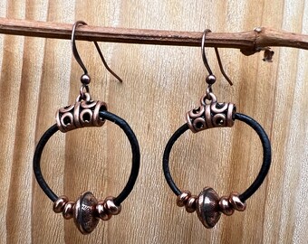 Copper earrings on black leather